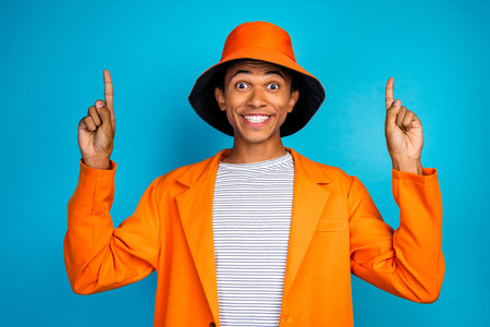 Photo of positive guy point up empty space wear stylish trend suit isolated blue color backgroundの写真素材