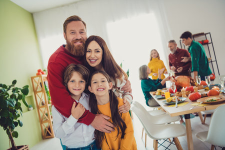 Photo of attractive big full family meeting hugging little kids eating thanksgiving holiday dinner good mood having fun at home indoorsの写真素材