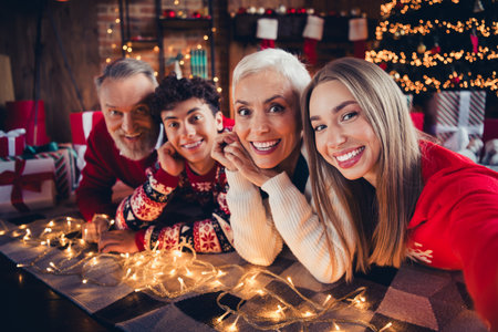 Photo of excited family having fun in christmas eve time night lying floor in house indoorsの写真素材