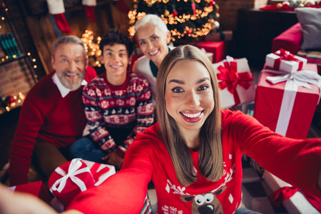 Photo of pretty girl make selfie photographing family in christmas gathering house indoorsの写真素材