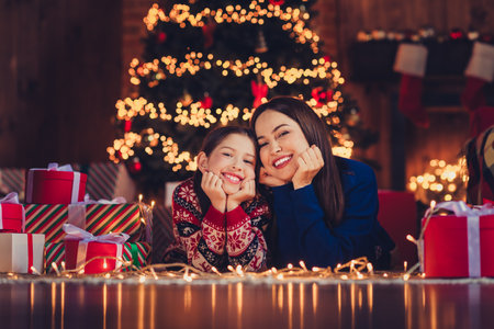 Full size photo of nice small daughter mother dreamy lying floor wear christmas clothes enjoy x-mas party decoration interior flat indoorsの写真素材