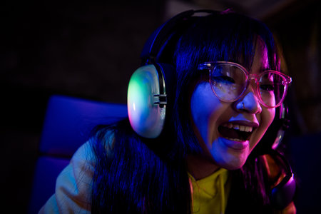 Photo of cute lovely girl laughing have fun play gamer laptop computer game late night indoors house lateの写真素材