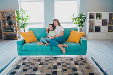 Photo of happy family lovely adorable mother enjoy time with daughter weekend together indoors cozy living roomの写真素材