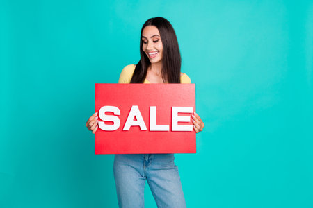 Portrait of nice young woman sale placard wear top isolated on turquoise color background