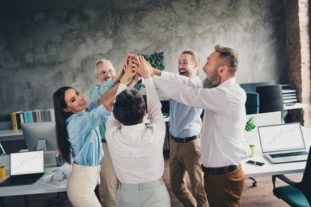 Photo of teamwork people working together brainstorm highfive comfortable modern office loft room interior indoors workspaceの写真素材