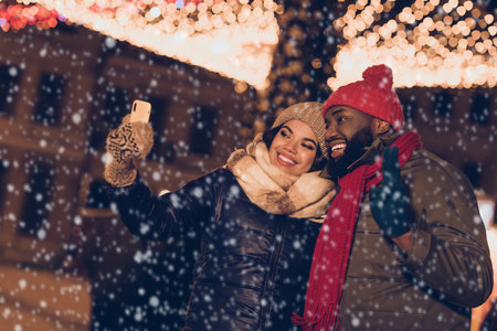 Photo of sweet funky husband wife wear winter season clothes video talk device xmas noel greetings outside urban city streetの写真素材