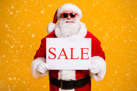 Portrait of his he nice attractive cheerful cheery confident fat Santa holding in hands board sale...