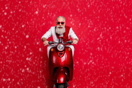 Portrait of funky elderly person in eyewear eyeglasses driving bike screaming wearing white pullover sit ob motor bike isolated over red backgroundの写真素材
