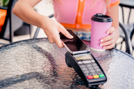 Portrait of charming positive girl drink cashless payment terminal cafe restaurant terrace outsideの写真素材