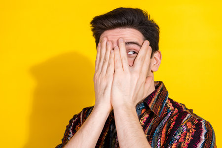 Portrait of nice young man close face eye look empty space wear shirt isolated on yellow color backgroundの写真素材
