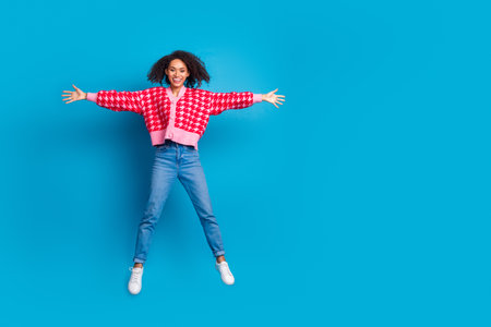 Portrait photo of american beautiful girl with curly hair wearing red shirt jumping star symbol...