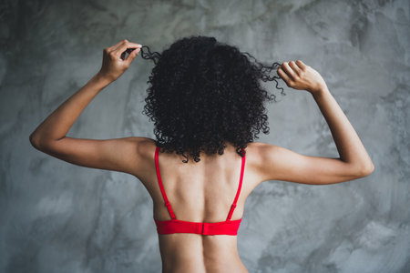 Cropped photo of gorgeous young lady back view hold strand haircare wear red lingerie isolated concrete wall studio background no retouchの写真素材