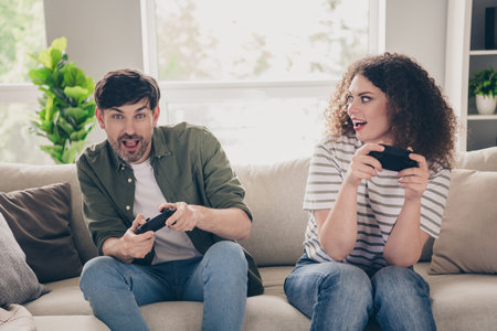 Portrait of two young partners enjoy play video games living room flat indoors