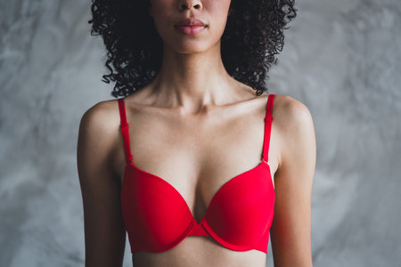Cropped photo of attractive young girl breast bra shopping wear red fashion lingerie isolated concrete wall background no filterの写真素材