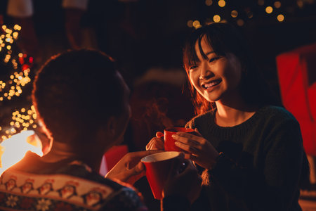 Photo of cute young couple drinking cacao dressed christmas outfit home party decoration interior...
