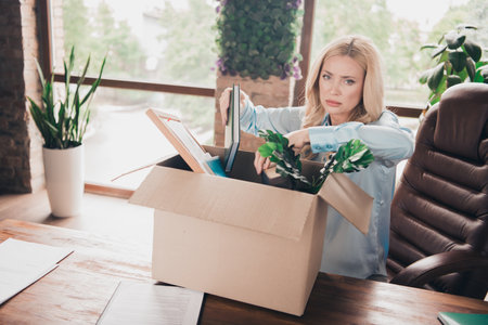 Portrait of young business woman sad sullen face pack belongings box fired loft interior business...