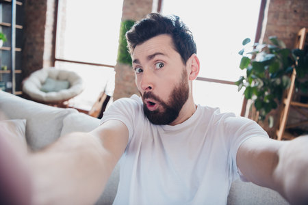 Photo of attractive funky crazy man wear pajama take selfie picture live stream broadcast weekend morning living room indoorsの写真素材