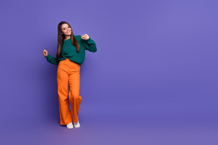 Full body portrait of pretty young girl dance empty space ad isolated on violet color backgroundの写真素材