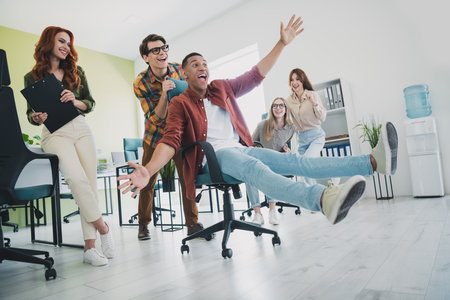 Photo of group five young corporate workers ride chair workstation office business center indoorsの写真素材