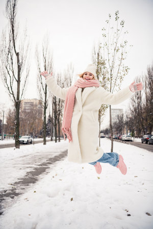 Photo of cheerful carefree girl enjoy winter rest relax jumping outside fresh air dayの写真素材