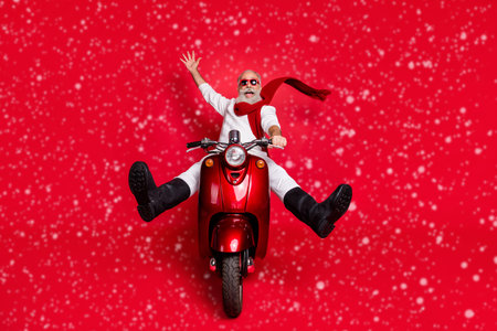 Full body photo of funky retired person screaming driving bike wearing white jumper boots pants trousers isolated over red backgroundの写真素材