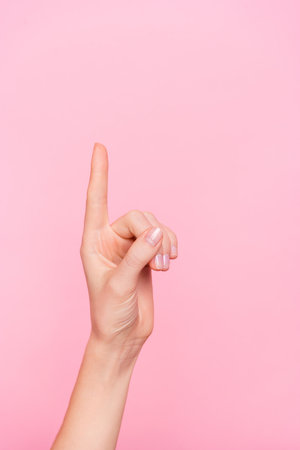 Cropped close up vertical portrait of girl finger direct up empty space isolated on pink color backgroundの写真素材