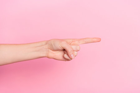 Cropped close up photo of lady hand finger pointing empty space blank isolated on pink color backgroundの写真素材