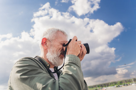 Photo of attractive professional seniour guy wear khaki shirt taking photos outdoors urban city streetの写真素材