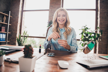 Photo of successful corporate worker lady hold nails paint gel desk wear shirt modern loft interior office indoorsの写真素材