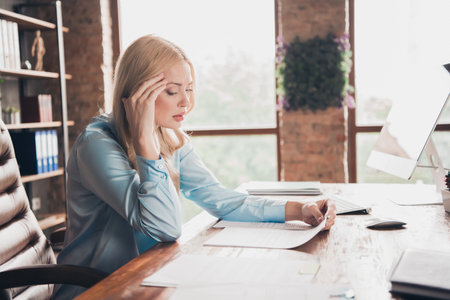 Profile photo of professional corporate worker lady read document desktop wear shirt modern loft interior office indoorsの写真素材