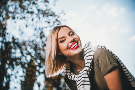 Photo of pretty young blonde woman dreamy smile wear khaki clothes tied shoulders sweater walk...