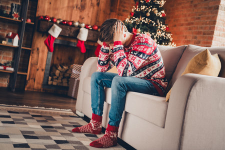 Photo of unhappy upset guy wear print jumper celebrating xmas feeling lonely indoors room home houseの写真素材