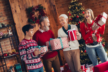 Portrait of four family members hold giftbox xmas new year enjoyment home flat indoors