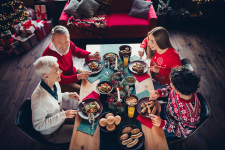 Above view portrait of big friendly family enjoy food communicate xmas new year celebration flat indoorsの写真素材