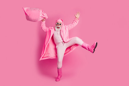 Full body portrait of charismatic crazy man wear bathrobe boots hold christmas bag empty space isolated on pink color backgroundの写真素材