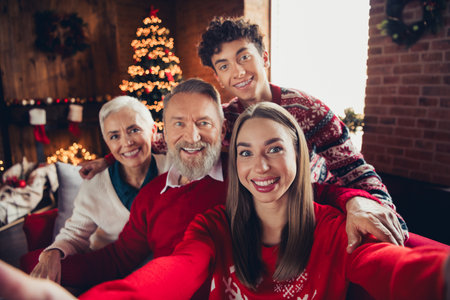 Portrait of four family members embrace make selfie toothy smile xmas new year enjoyment home flat indoorsの写真素材