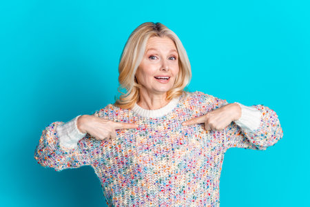 Photo of nice aged woman point fingers self wear pullover isolated on teal color backgroundの写真素材