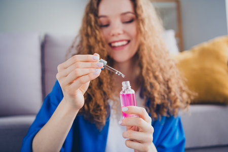 Photo of pretty cute girl beauty blogger advertising selling cosmetics moisturizing skincare serum indoorsの写真素材