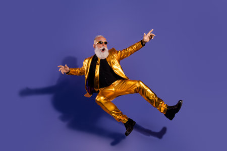 Full size photo of old macho man falling dance dressed glamour stylish golden outfit party isolated on purple color backgroundの写真素材