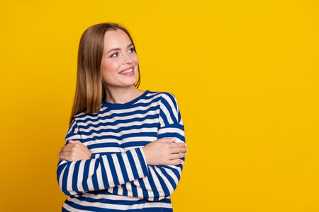 Photo of adorable cute woman wear striped stylish clothes arms folded isolated on yellow color backgroundの写真素材