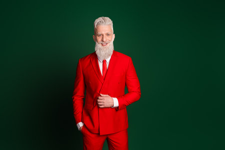 Photo of modern stylish santa posing empty space wear red christmas suit isolated on green color backgroundの写真素材