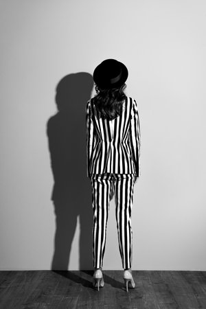 Behind full-size full-length view photo of charming elegant tender gentle beautiful attractive stunning slender classy woman with long brown curly hair isolated on gray backgroundの写真素材