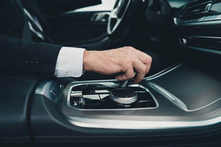 Businessman in formalwear drives his luxury car on city streets, symbolizing travel and efficiencyの写真素材