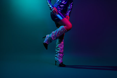 Cropped photo of attractive young woman dancing legs dressed stylish party retro clothes isolated on dark backgroundの写真素材