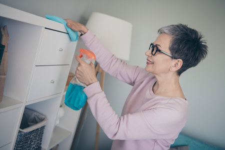 Photo of adorable sweet lady wear pink sweatshirt doing daily cleaning indoors room home houseの写真素材