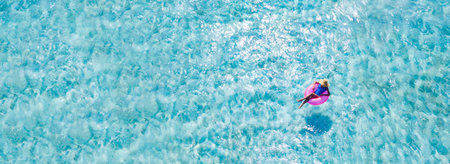 Top above high angle aerial drone view of her she slim fit girl floating on rubber ring in pure azure blue sea water dream tour enjoy joy sunny weather outdoor calm peaceful activityの写真素材