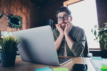 Photo of funky scared boss wear shirt biting fingers working modern device indoors workplace...