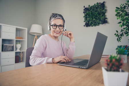 Photo of positive good mood woman dressed pink sweatshirt earphones chatting modern gadget indoors...
