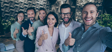 Photo of group business people six diversity members pause working process making selfies raise thumbs up good mood best friends team company big loft interior office indoorsの写真素材