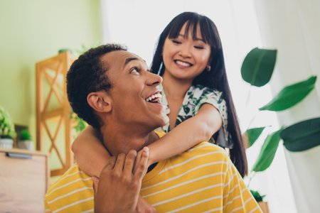 Photo of lovely affectionate couple wear t-shirts weekend time together indoors house living room apartment flatの写真素材